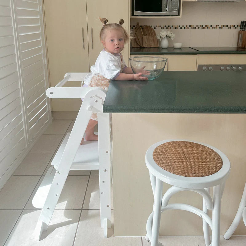 Child enclosed in MILA learning tower at modern kitchen counter - myduckling