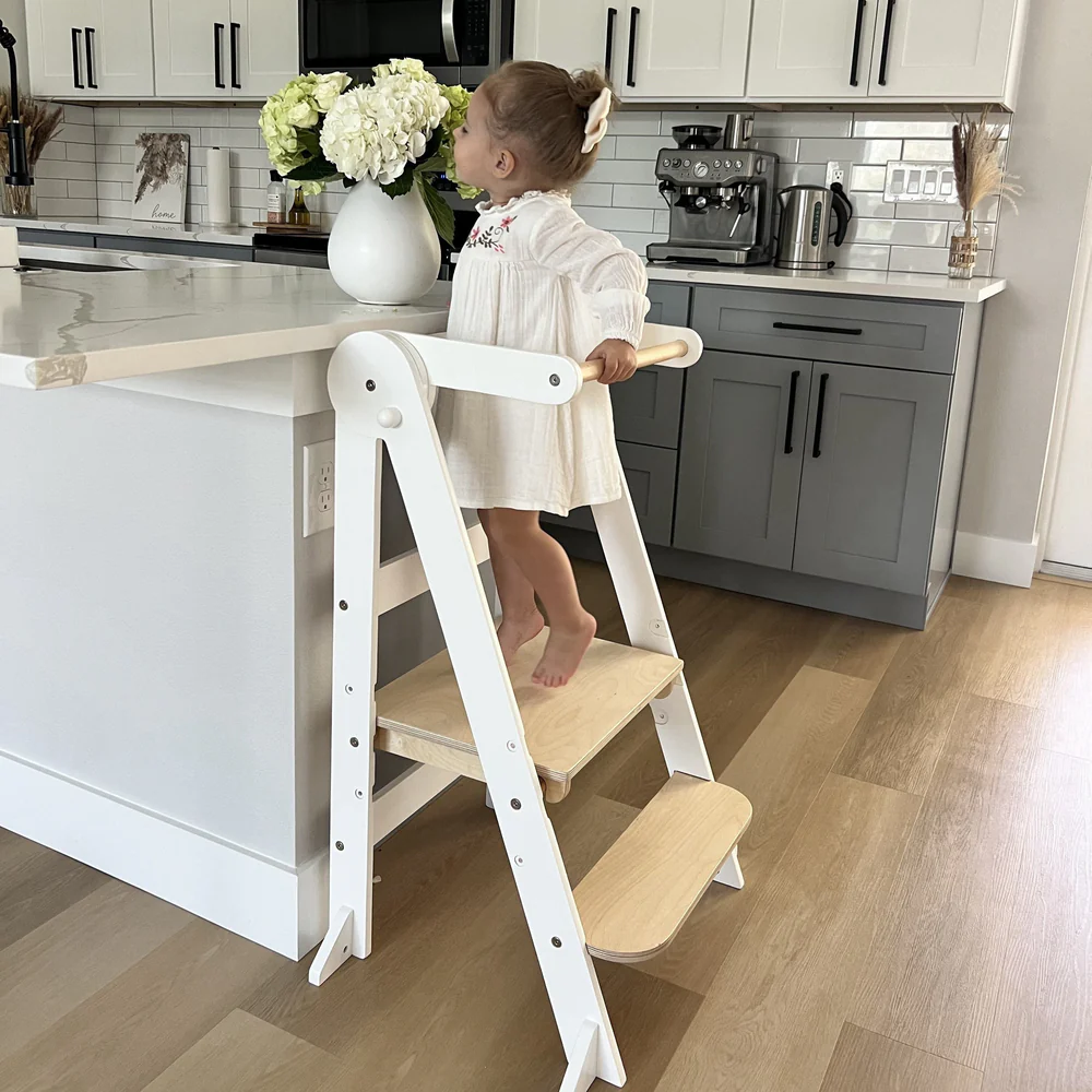 Toddler in White MILA learning tower helping at kitchen bench - myduckling